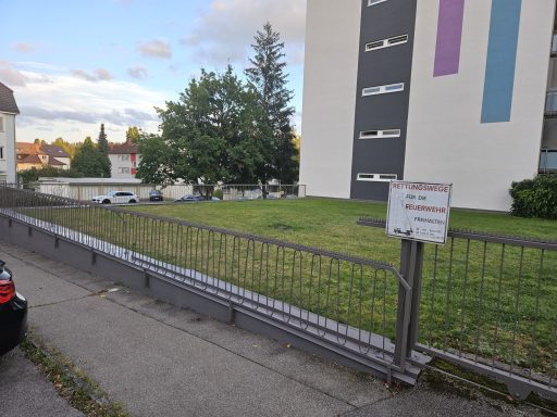 Objekt Nr.6 - VS-Schwenningen Grünfläche neben einem Gebäude mit einer Absperrung und einem Informationsschild.